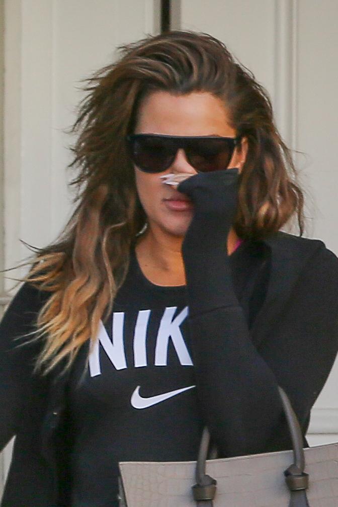 Khloe Kardashian covers her lips while exiting Epione Cosmetic Dermatology