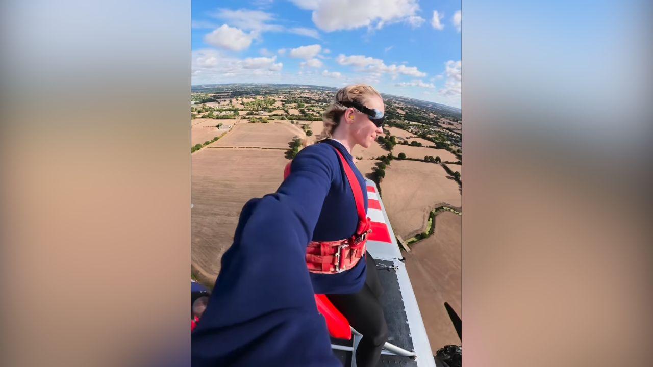 image of Sydney Sweeney strapped herself to the top of a single-engine airplane while it performed several upside-down loops in a daring stunt.