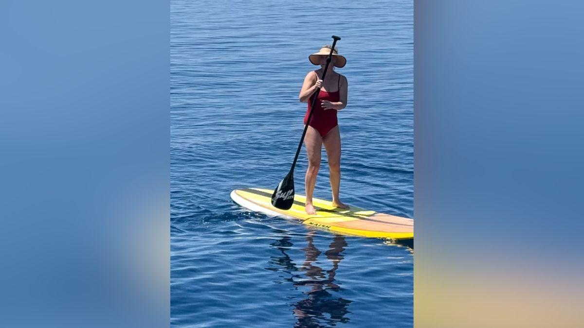 Image of Amy Schumer sizzled in a red bathing suit while paddleboarding.