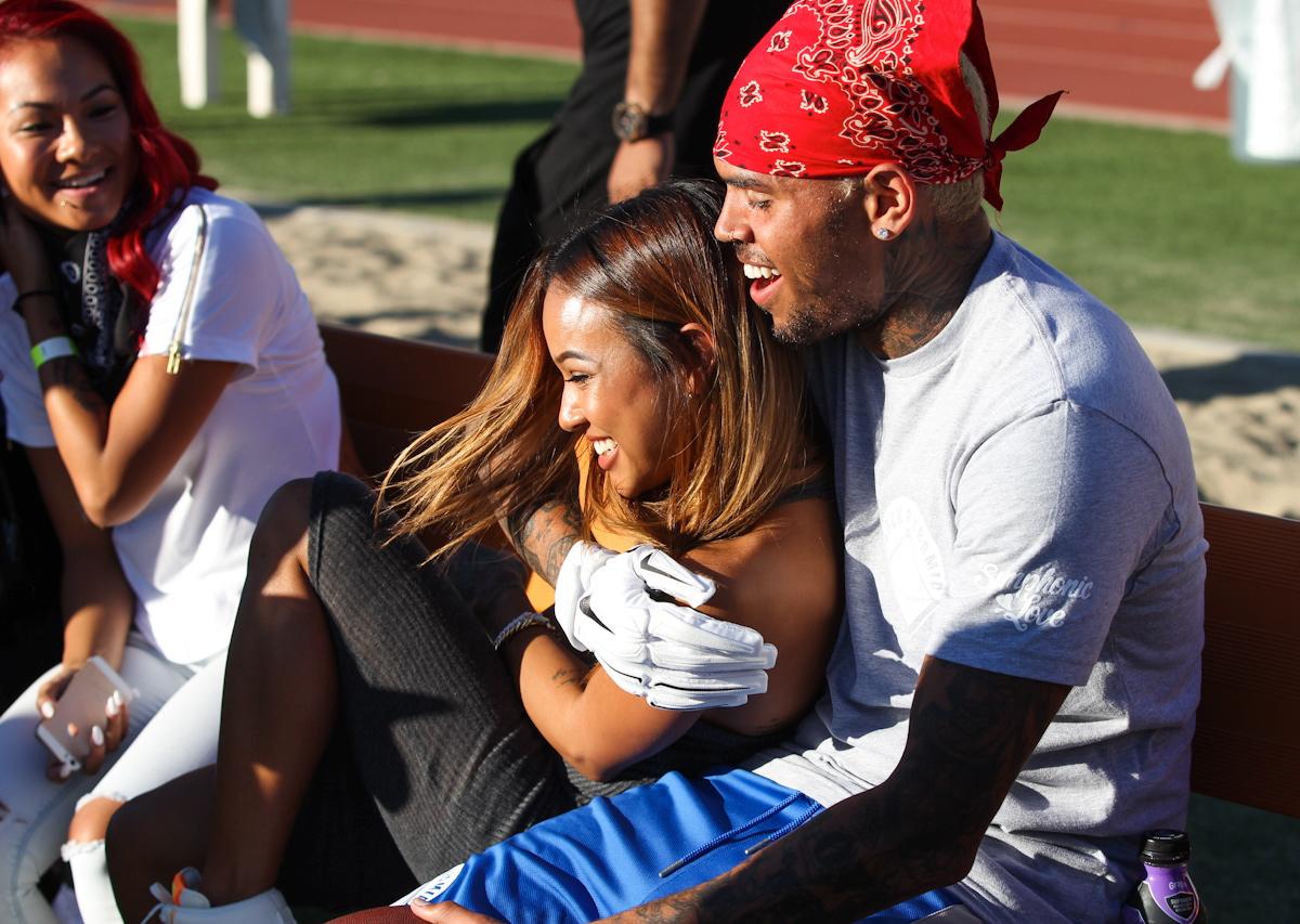 Chris Brown cuddles up to on/off girlfriend Karrueche Tran as they attend his charity footbal game in Los Angeles, CA