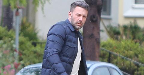 A scruffy Ben Affleck jaywalks in the rain