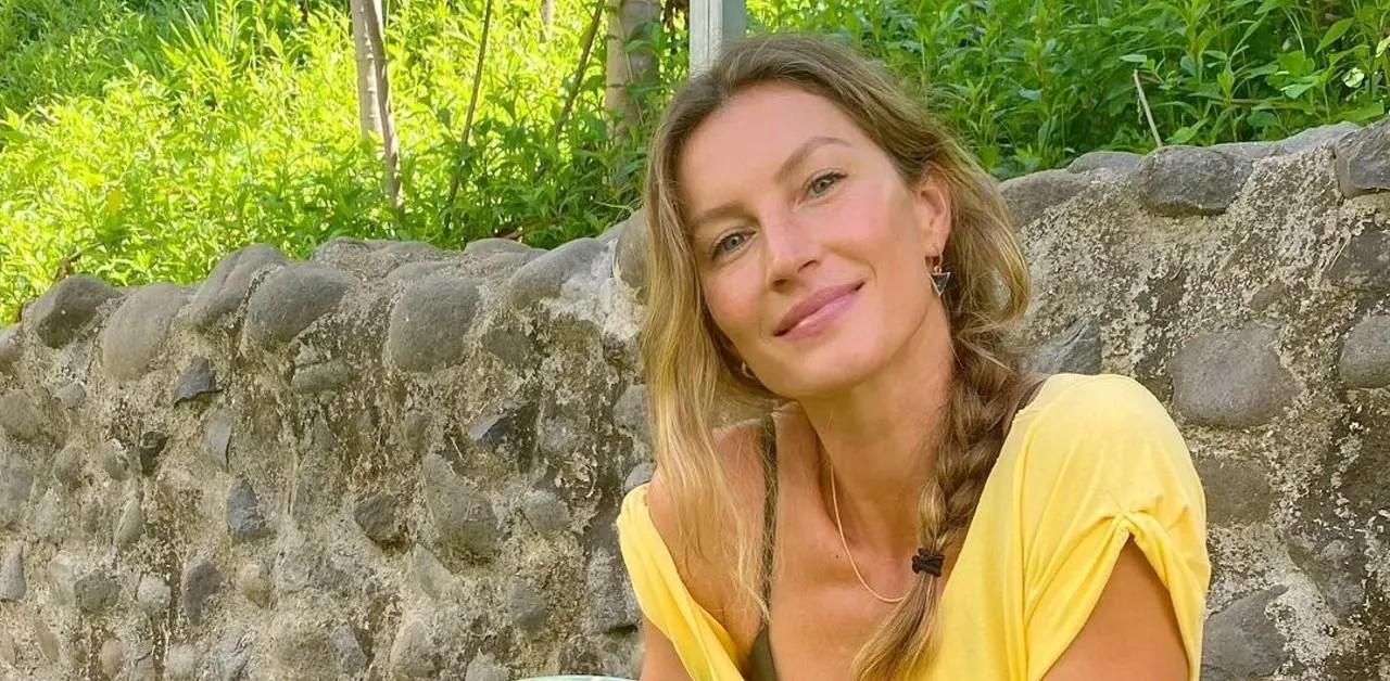 Gisele Bundchen sits on suitcase on beach in bizarre pics after