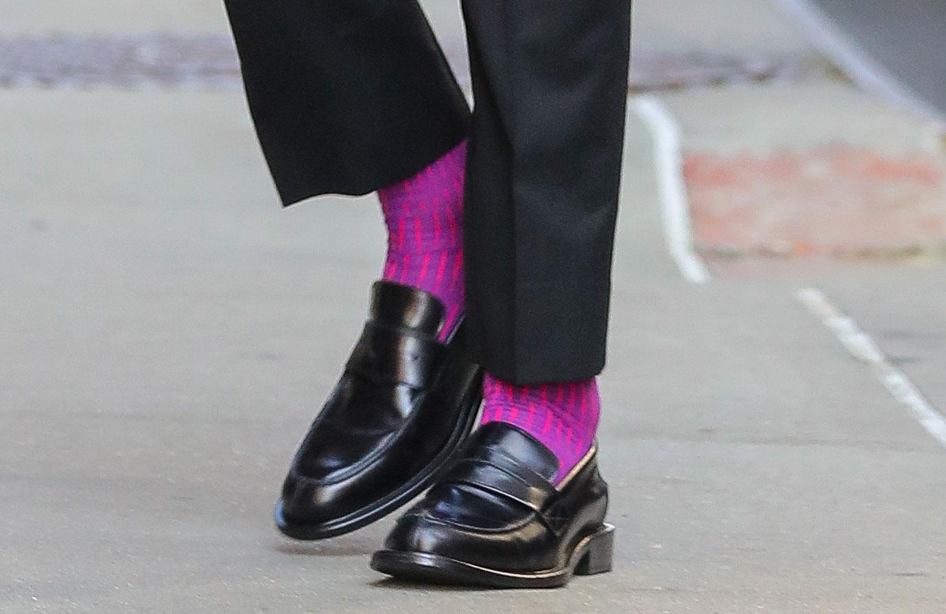 john krasinski seen wearing a red shirt and a purple socks while arrives at the late show with stephen colbert ok