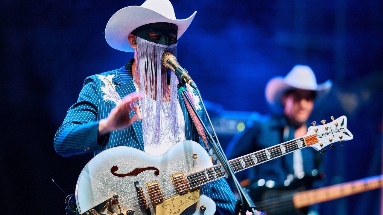 Image of Orville Peck on stage.