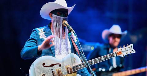 Image of Orville Peck on stage.