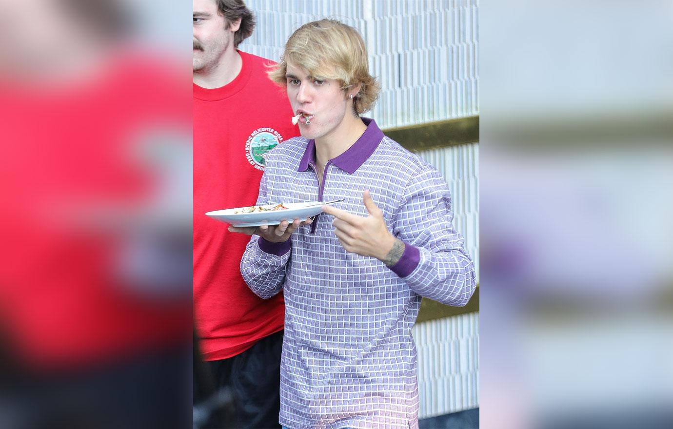 Birthday boy Justin Bieber stuffs his face as he leaves the London West Hollywood Hotel