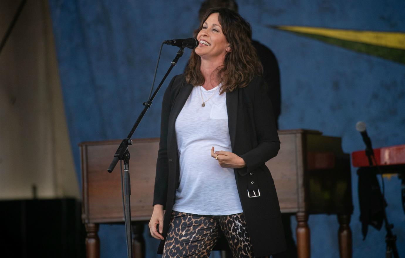 A pregnant Alanis Morissette sets the stage ablaze with her talent in a long, black sweater, white T-shirt and leopard print pants.