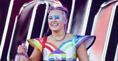 Photo of JoJo Siwa onstage holding a jug of vodka.