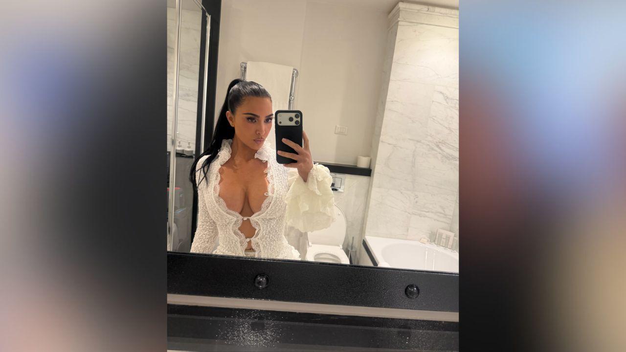 image of Kim Kardashian showed off a daring white lace ensemble featuring a plunging top, semi-sheer pants and dramatic ruffled details.