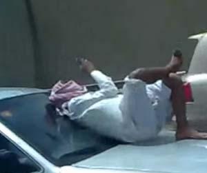 Saudi_man_texting_car_hood_freeway_rotator.jpg