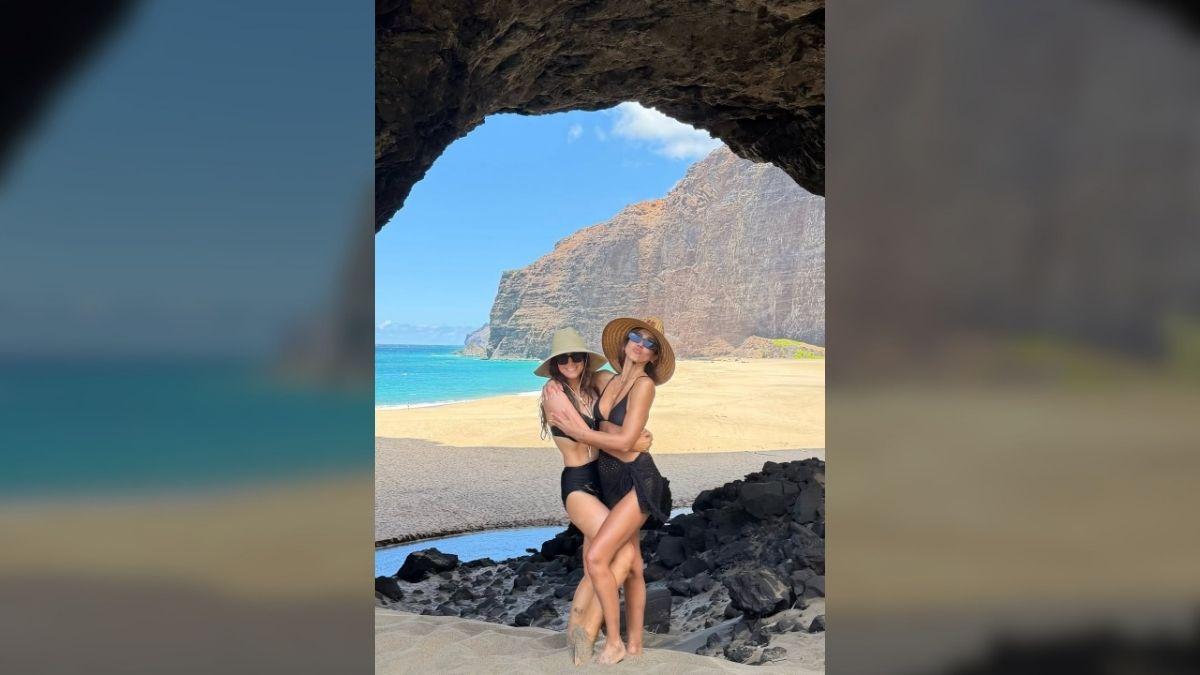 Photo of Jessica Alba posed with a friend while on a beach vacation.