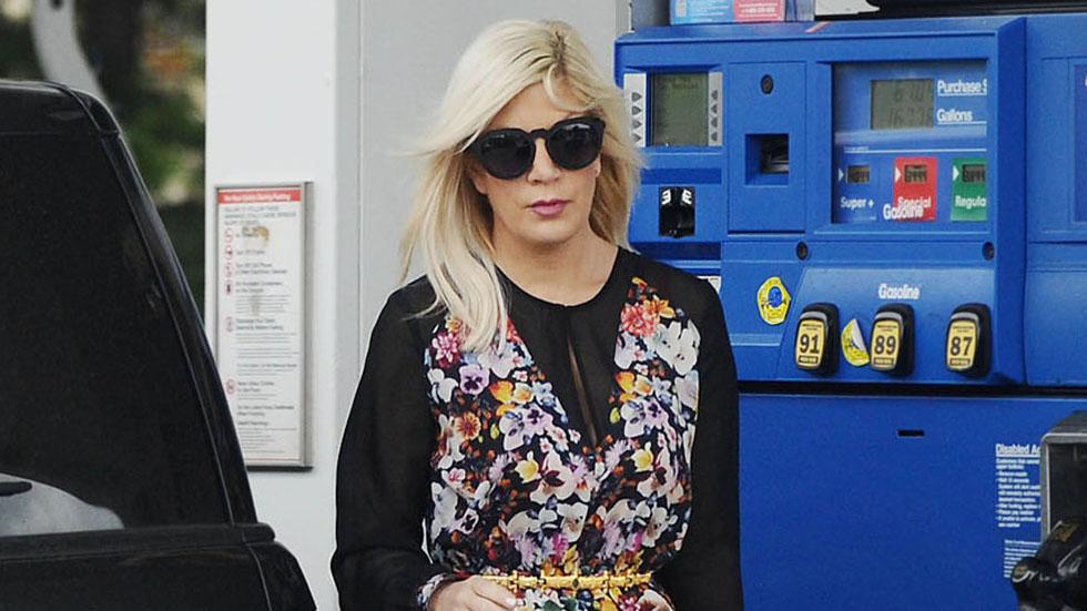 EXCLUSIVE: Tori Spelling pumps gas while stepping out in a floral print dress