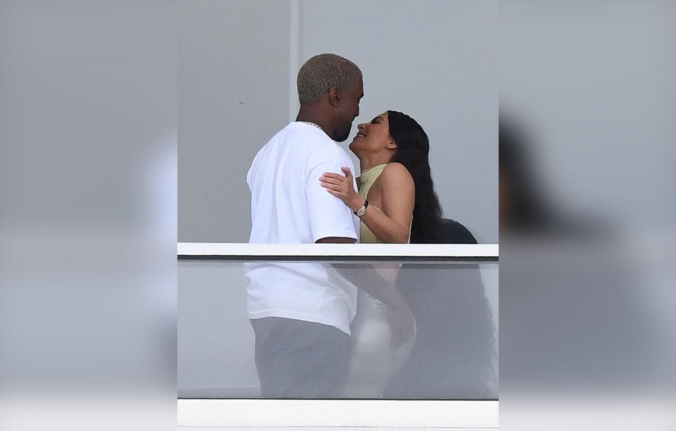 Kim and Kanye share a passionate kiss on the balcony of their new Miami pad