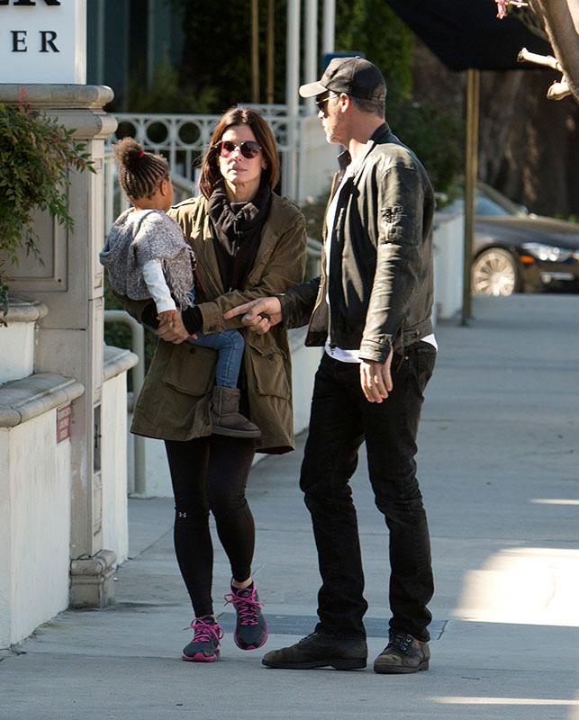 EXCLUSIVE: *** Premium Exclusive Rates Apply*** Sandra Bullock doesn&#8217;t look to impressed with boyfriend Bryan Randall as she holds her daughter Laila while they pick up coffee in Studio City, CA