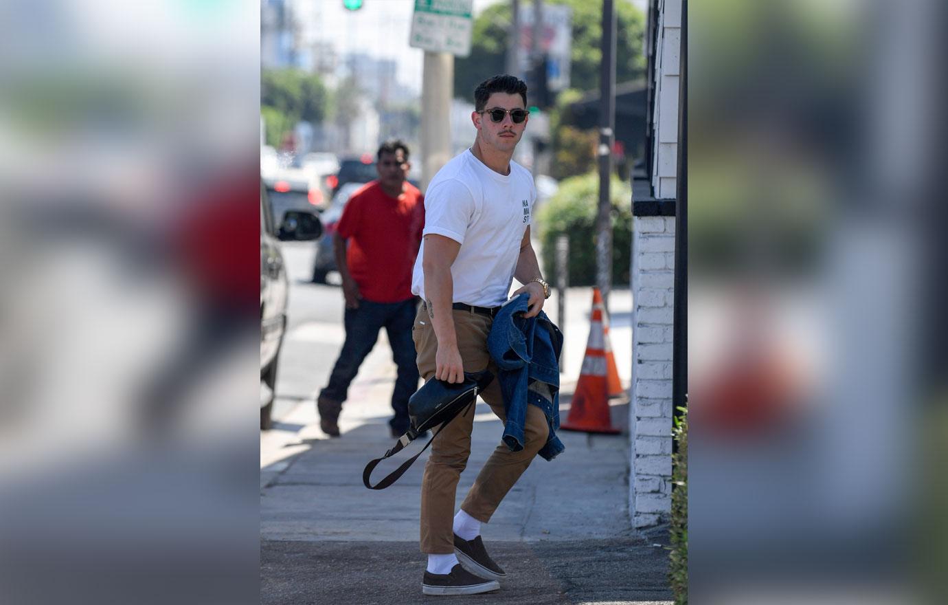 EXCLUSIVE: Nick Jonas sports a mustache as he arrives at a studio