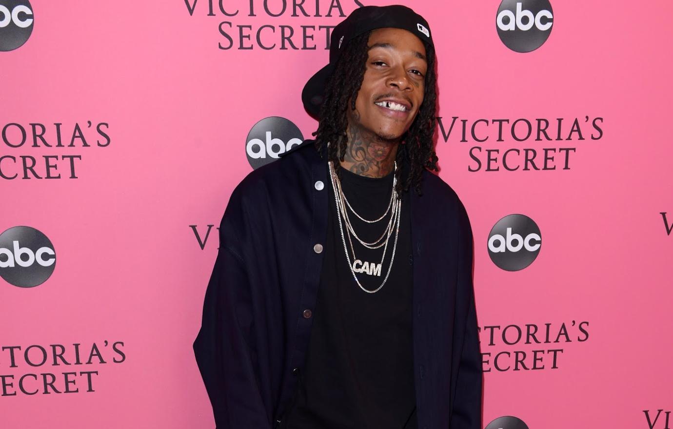 Wiz Khalifa wears all black and gold chains on the red carpet