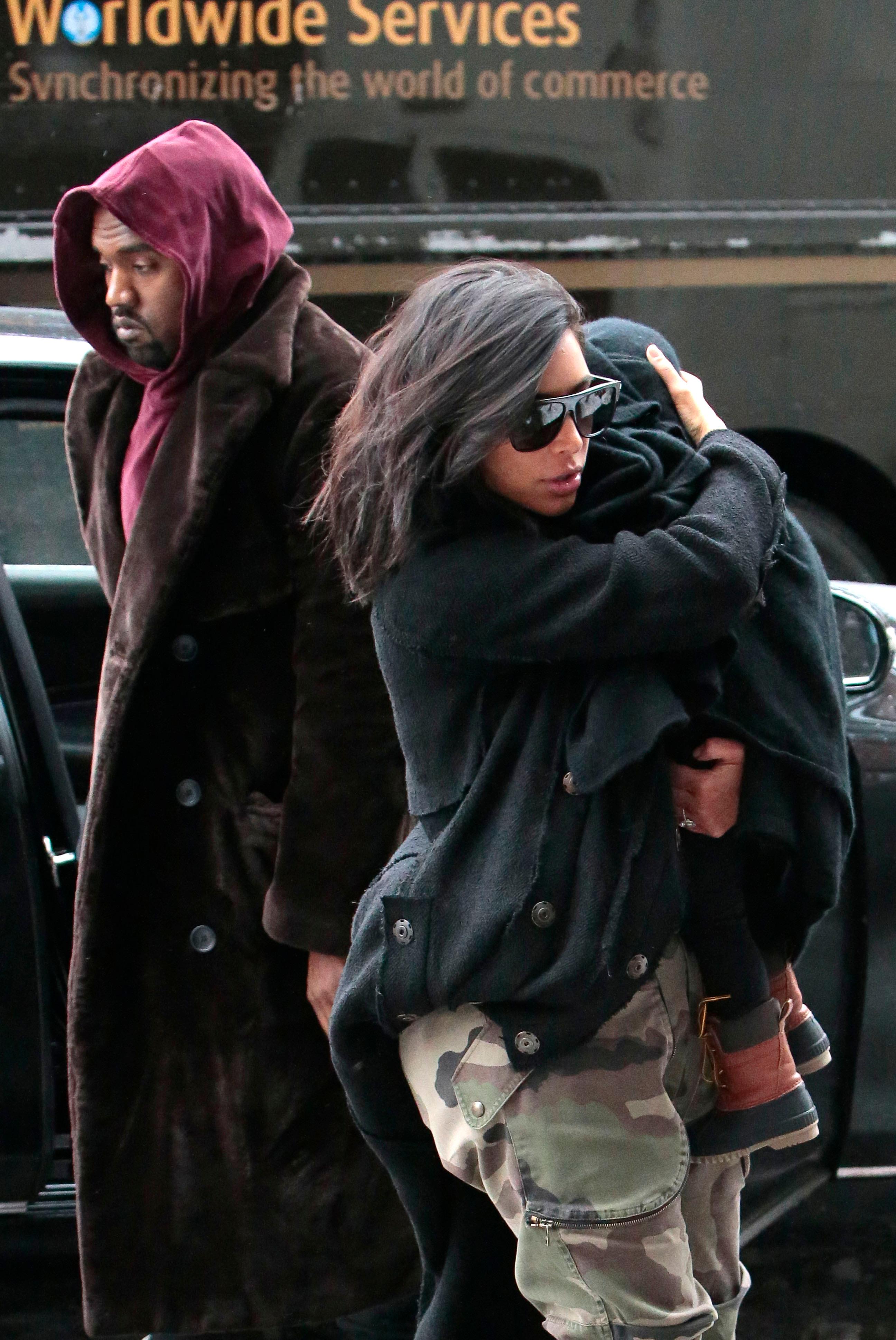 Kim Kardashian carries baby North West while navigating the snow with Kanye West in New York City