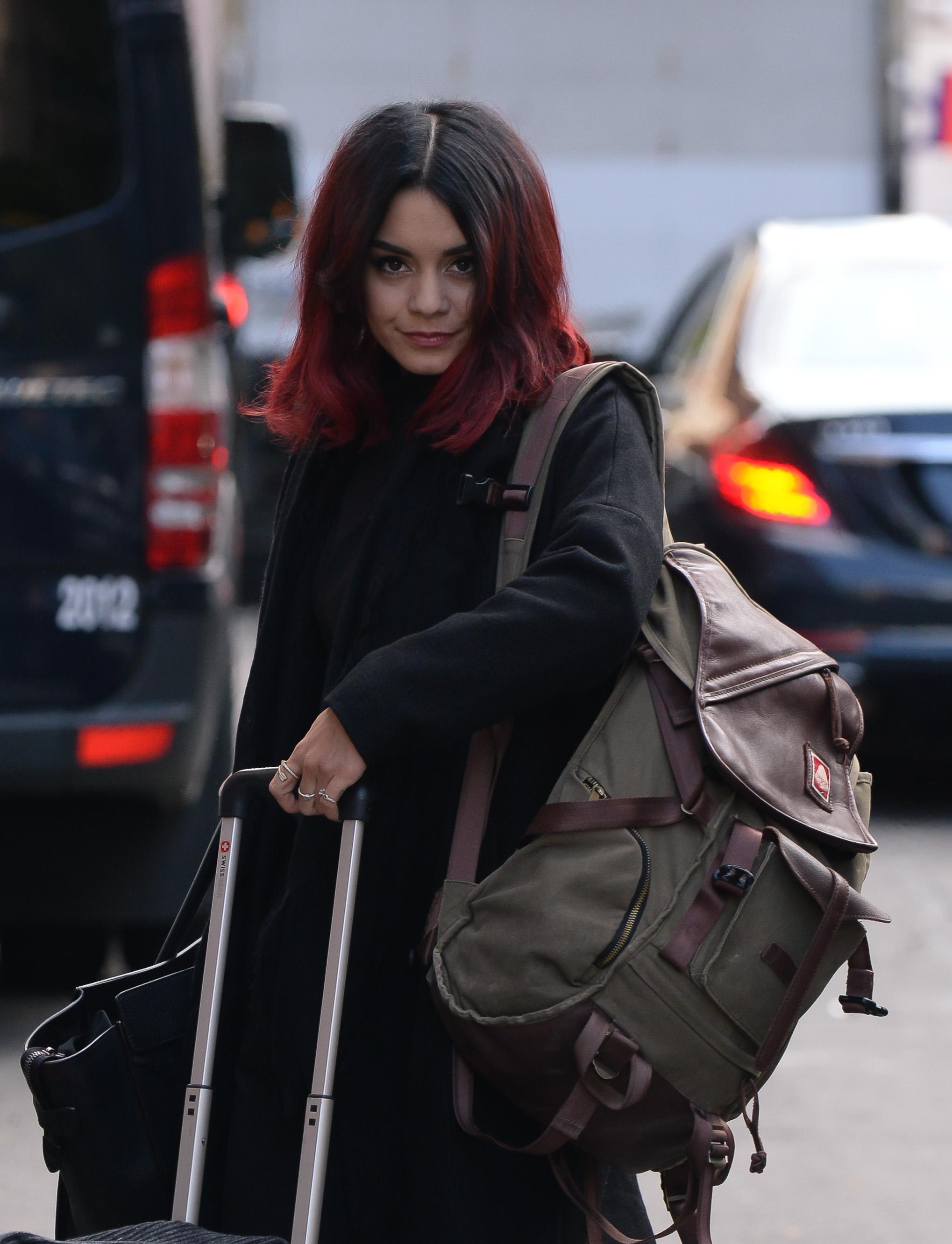 Vanessa Hudgens carries her own luggage as she leaves her NYC hotel