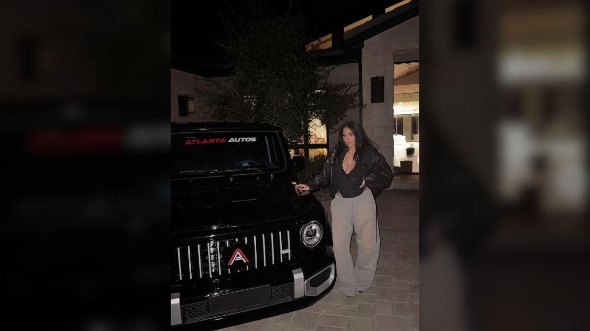 Image of Kim Kardashian posed in front of a luxe car.