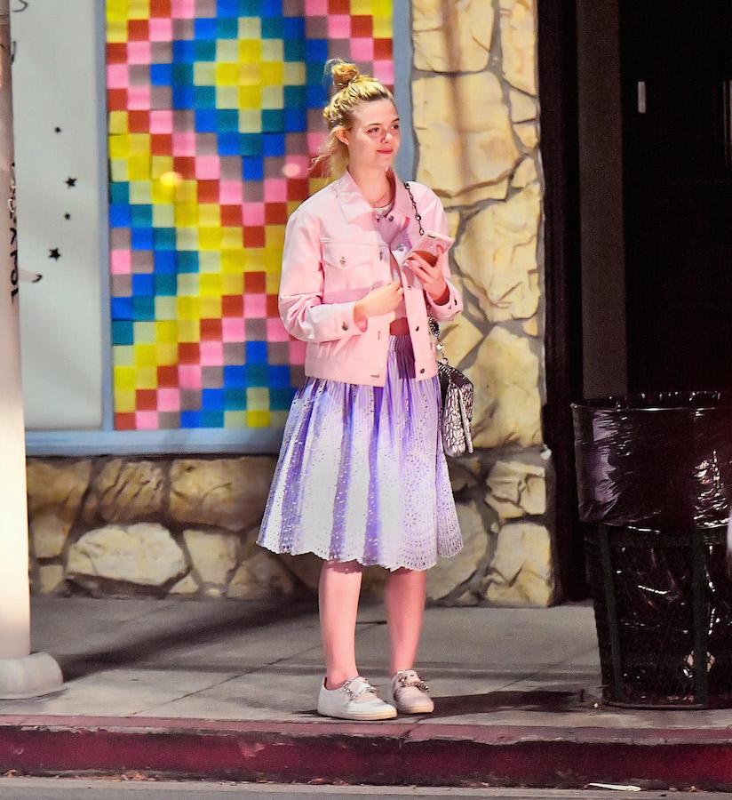 EXCLUSIVE: Elle Fanning sits on a curb and chats with a friend after dinner at Little Dom&#8217;s in Los Feliz, CA.