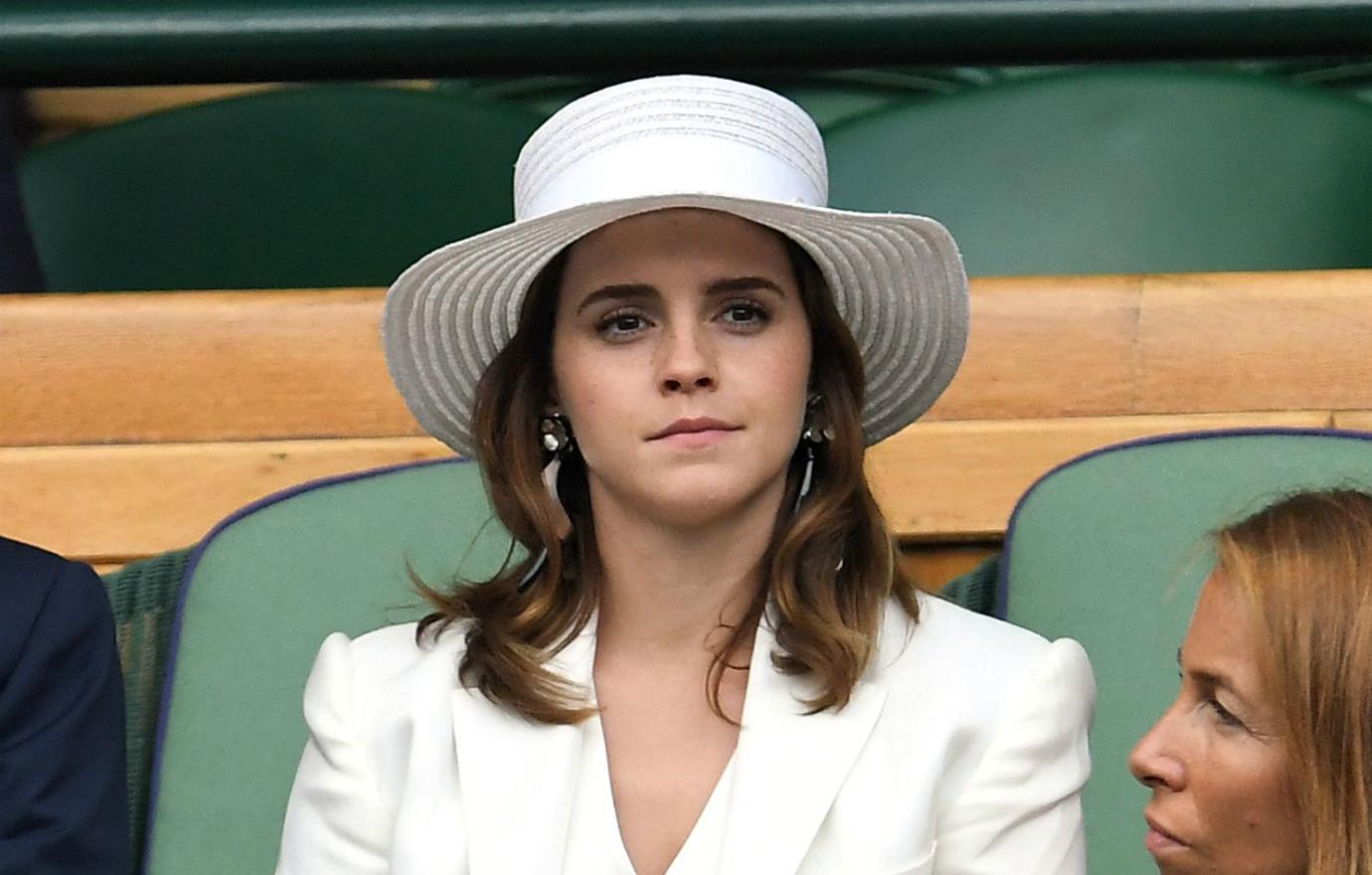 Emma wears a white outfit and white hat.