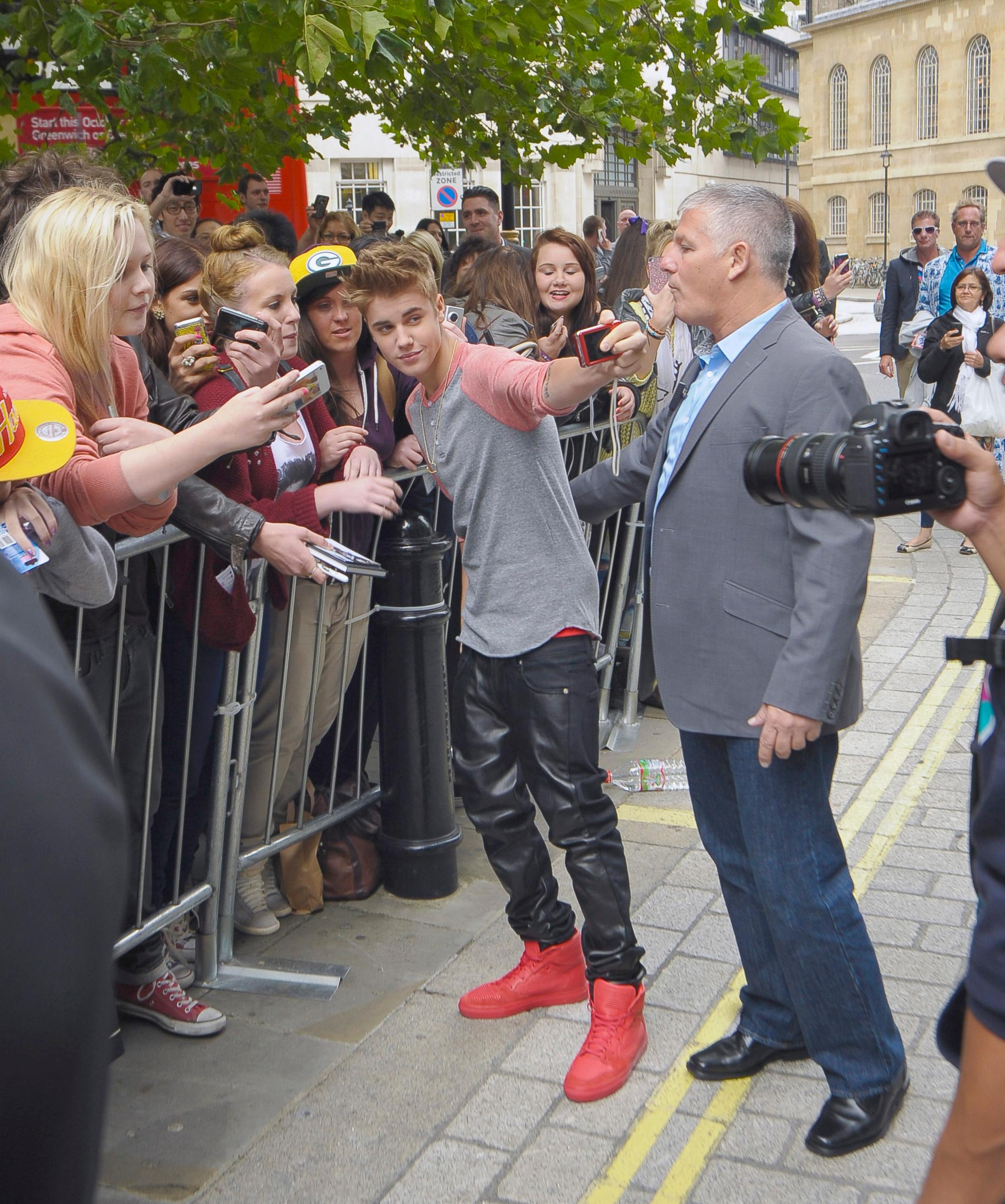 Justin Bieber is greeted by many fans and photographers leaving hotel in London