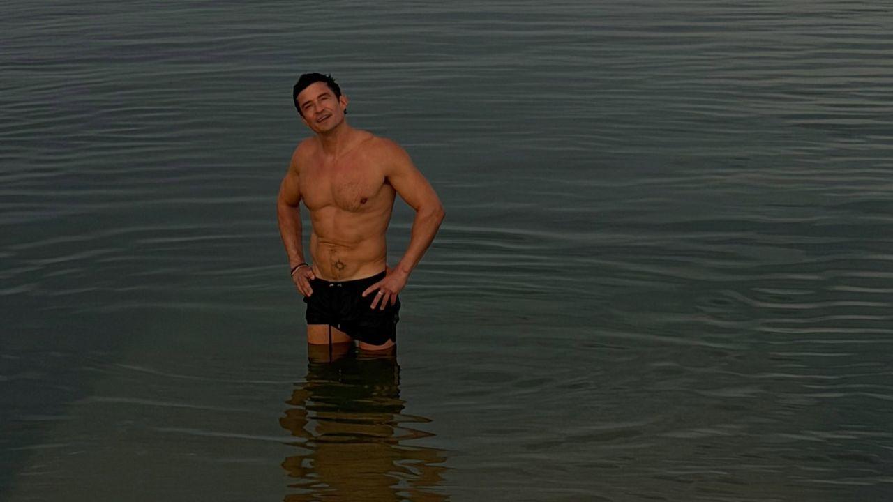 Image of Orlando Bloom put his muscular physique on display as he posed shirtless in the water.