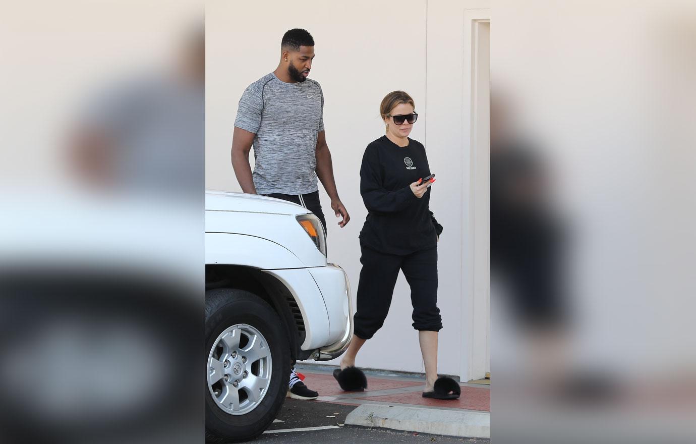 A barefaced Khloe Kardashian stops to take a photo with a fan after a laser session