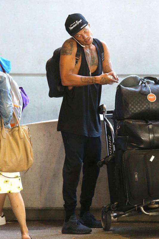 Jeremy Meeks hauls a huge cart of luggage through LAX