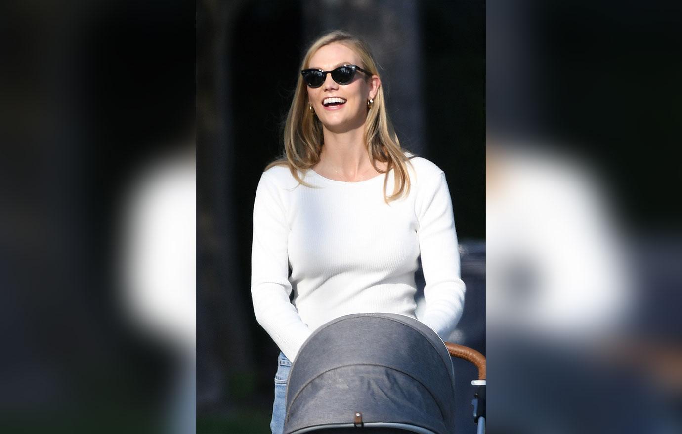 model karlie kloss smiles as she takes a walk with her baby and a friend