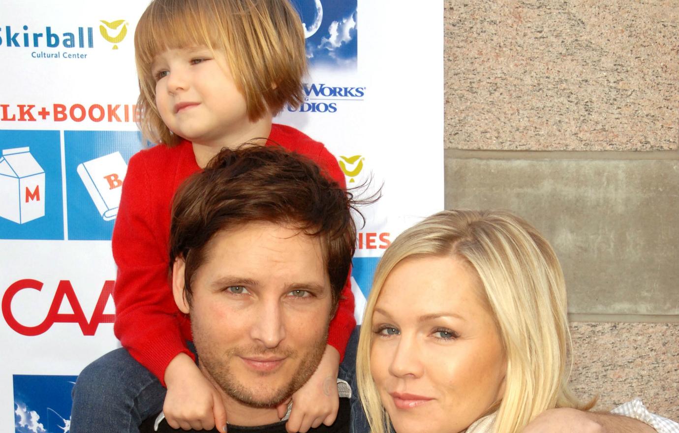 Jennie Garth and ex Peter Facinielli with their child on his shoulders.