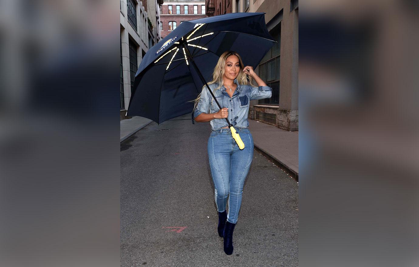 la la anthony holding umbrella