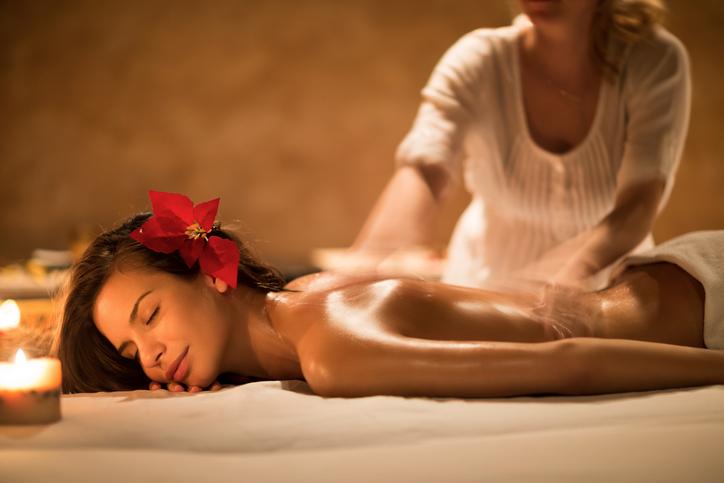 Relaxed woman enjoying in a back massage at the spa. Massage therapist's hands are in blurred motion