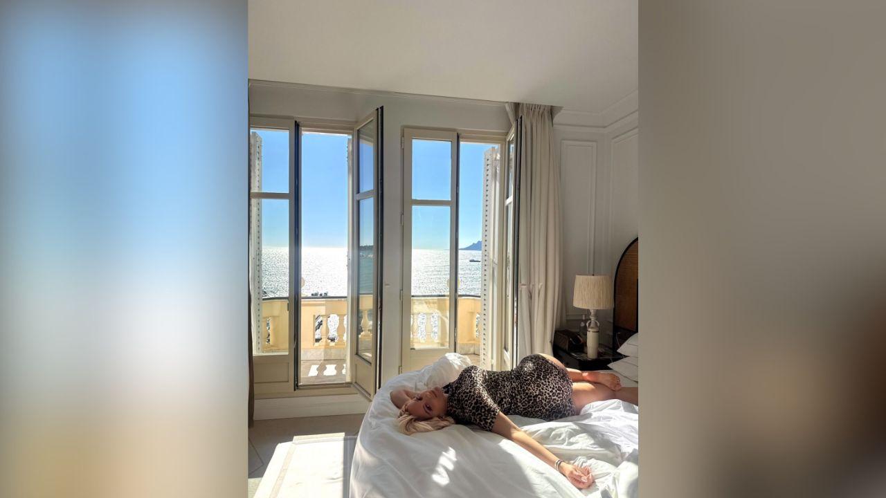 Image of The blonde beauty posed outside her room, which featured floor to ceiling doors opening onto a waterfront balcony.