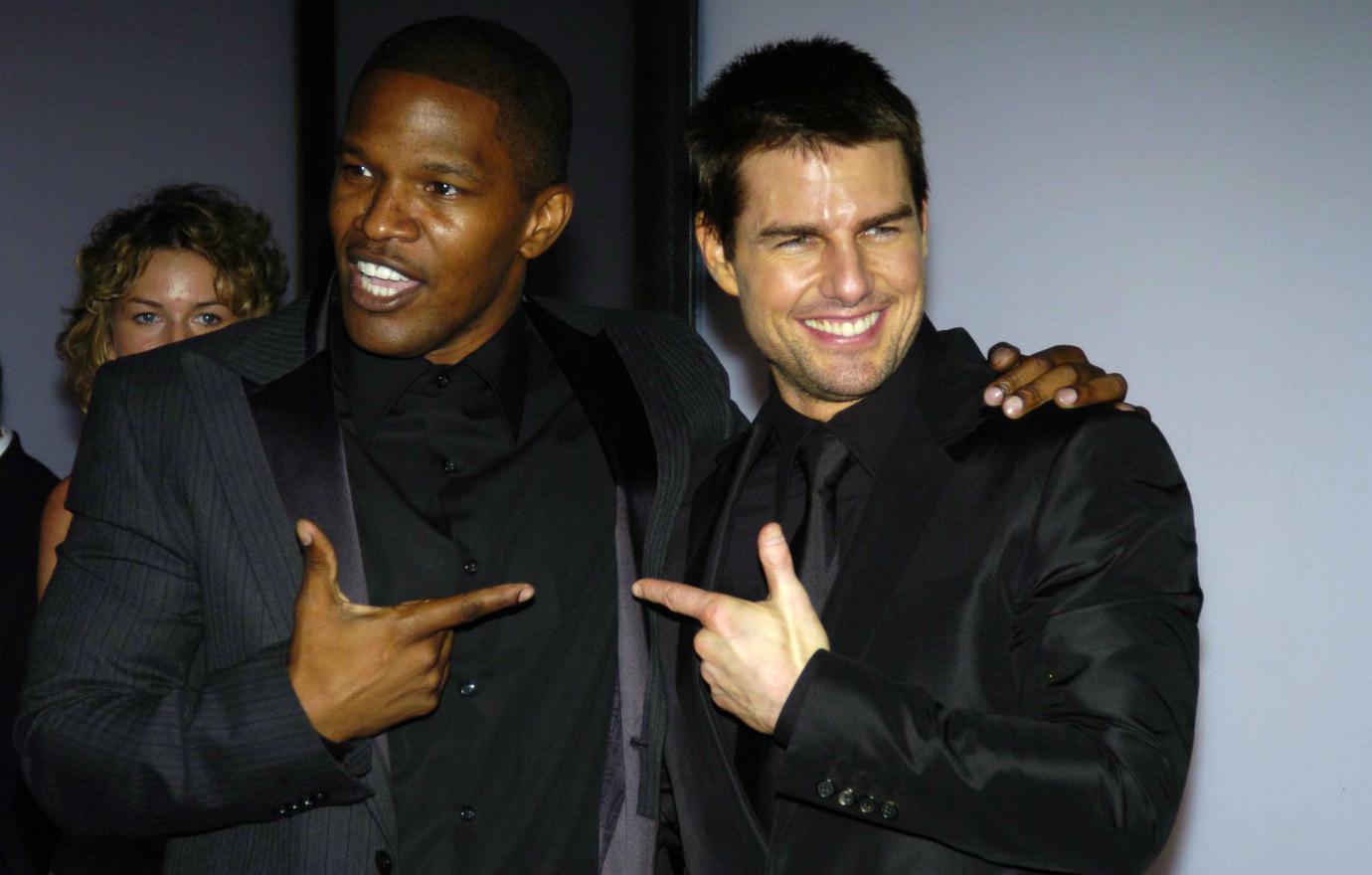 A fascinating photo of Jamie Foxx and Tom Cruise (both in black suits), seven years before Jamie and Katie Holmes would become a couple. Tom and Jamie were starring in Collateral.