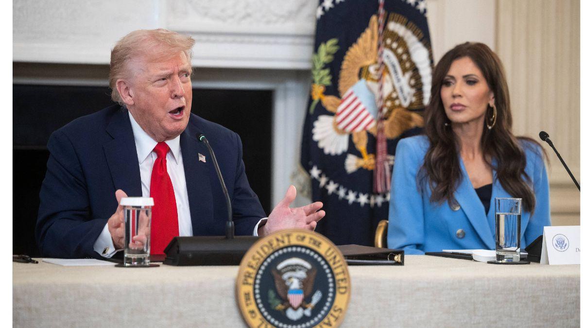 Image of President Donald Trump accepts a lot from DHS Secretary Kristi Noem.