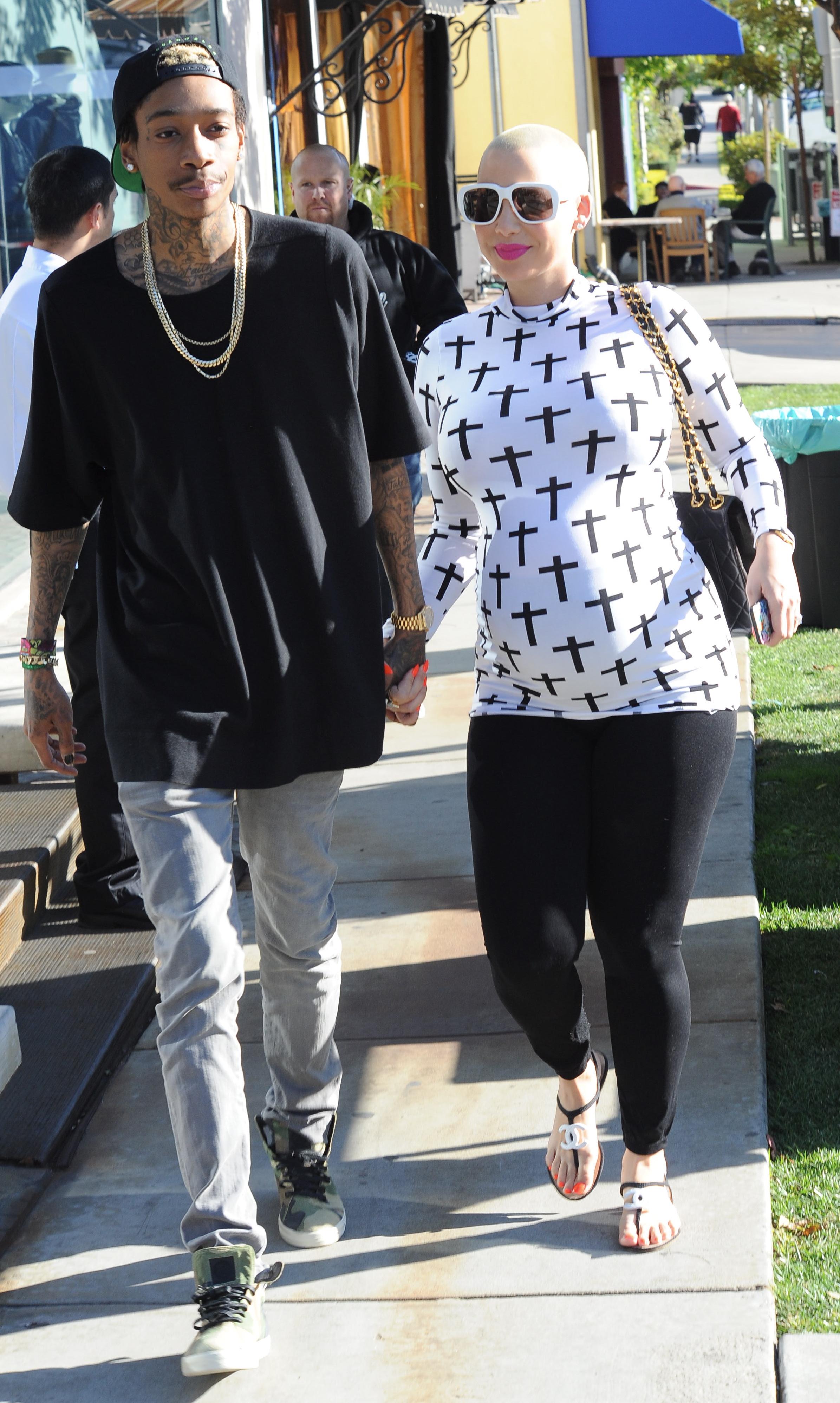 A very pregnant Amber Rose walks hand in hand with fiance Wiz Khalifa as they head to their car after shopping at Bel Bambini in Beverly Hills, CA