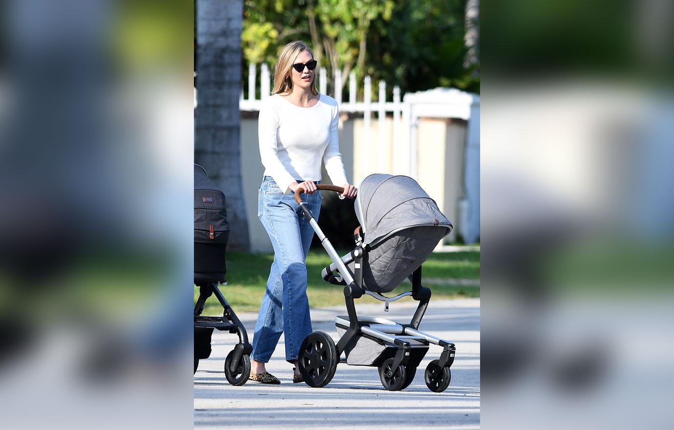 model karlie kloss smiles as she takes a walk with her baby and a friend