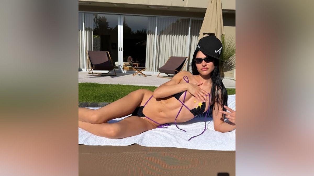 image of Amelia Hamlin relaxed by the pool in a tiny bikini.