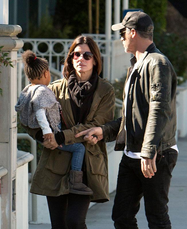 EXCLUSIVE: *** Premium Exclusive Rates Apply*** Sandra Bullock doesn&#8217;t look to impressed with boyfriend Bryan Randall as she holds her daughter Laila while they pick up coffee in Studio City, CA