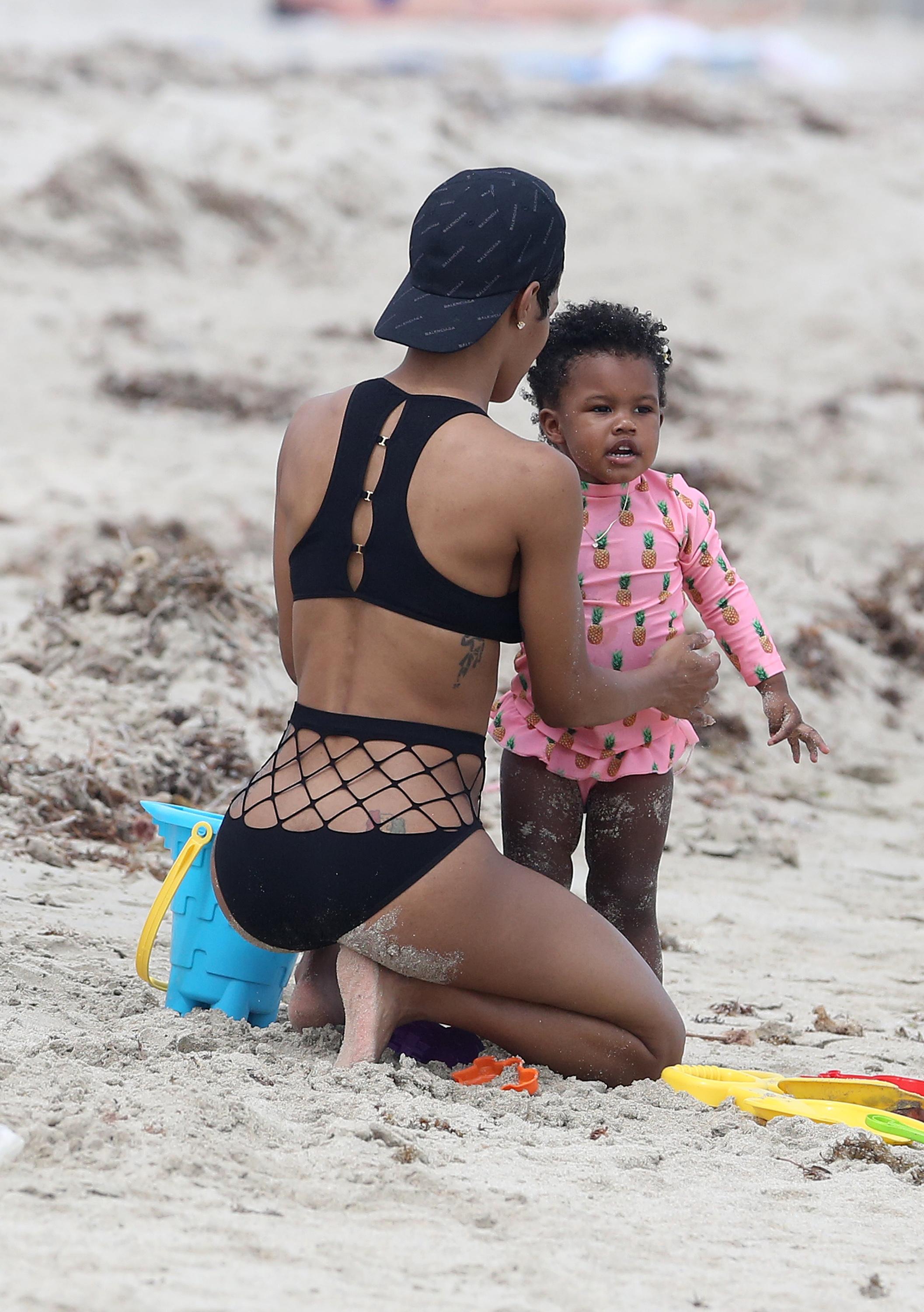 Singer Teyana Taylor shows off her abs in a black bikini on the beach in Miami