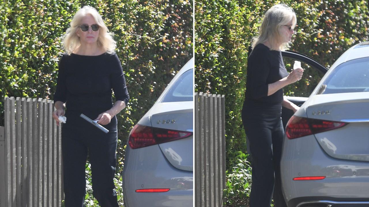 Photo of Deidre Hall cleaned the glass of her vehicle before leaving the area.
