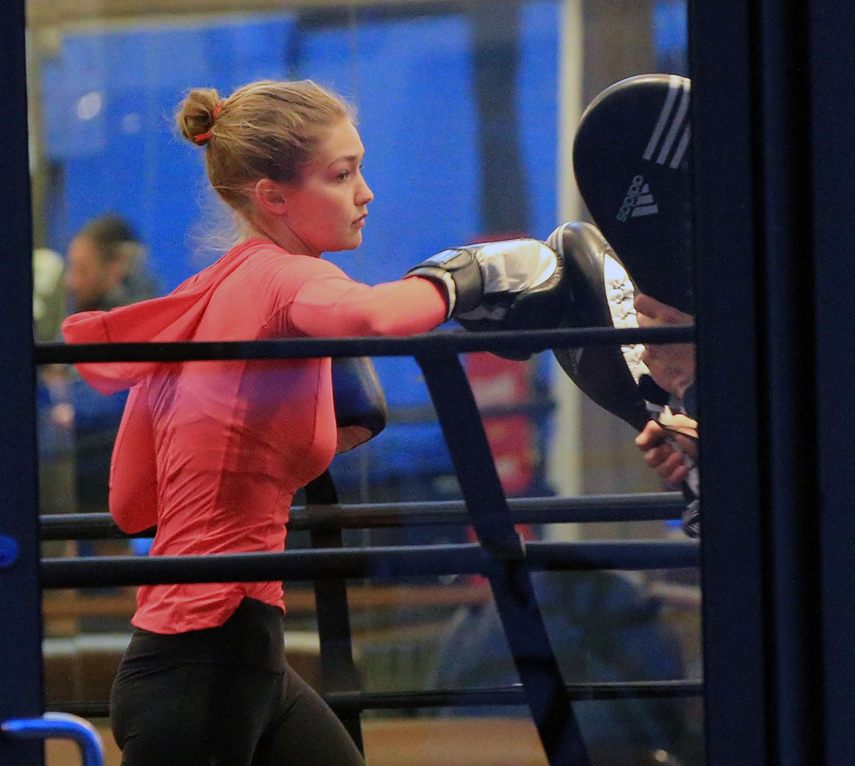 Gigi Hadid lands an uppercut on  her trainer at the boxing gym during a workout in NYC