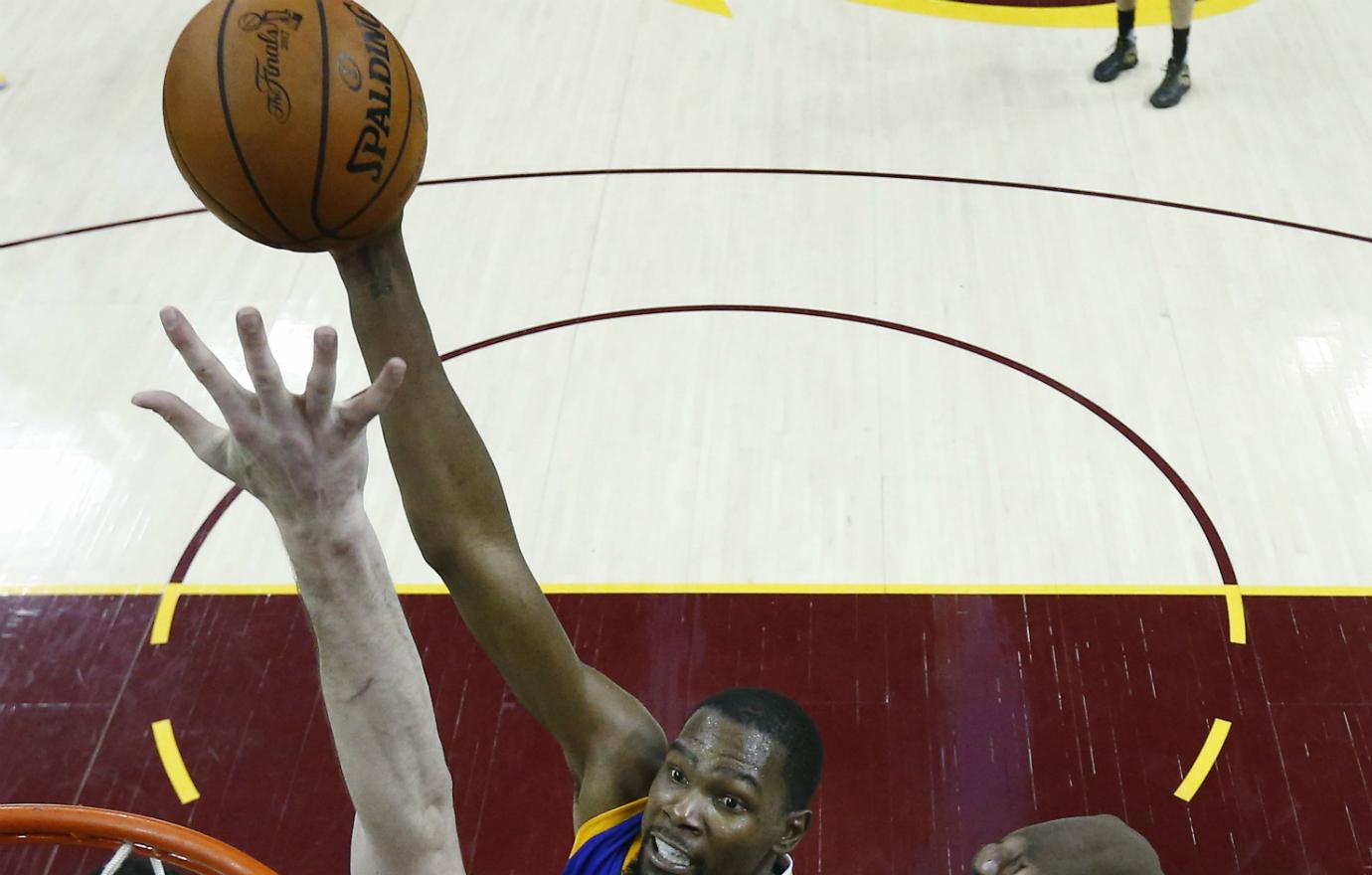 Thompson reaches up to slam dunk a ball.