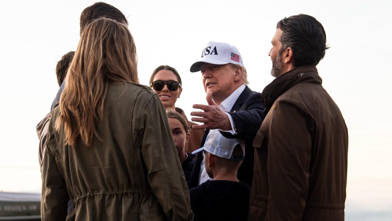 Image of Donald Trump pulled son Donald Trump Jr. in for an affectionate farewell as several of his grandchildren stood nearby.