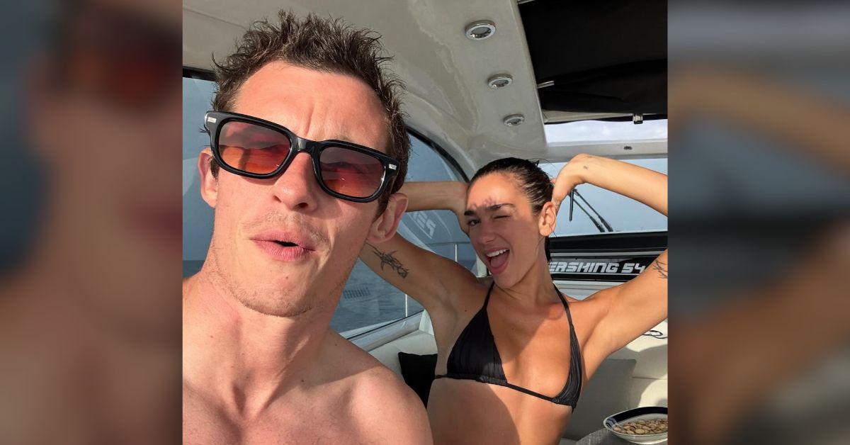 Image of Dua Lipa and Callum Turner lounged on a yacht.