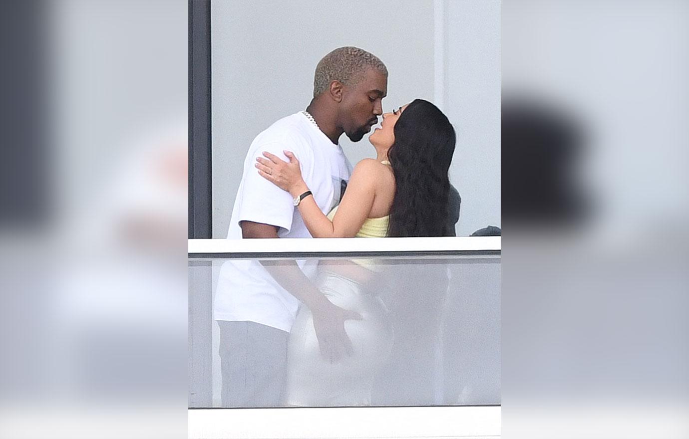 Kim and Kanye share a passionate kiss on the balcony of their new Miami pad