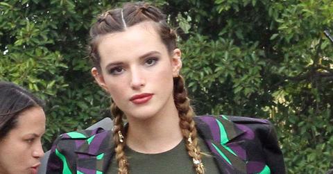 Bella Thorne is looking sexy in a dark green dress showing off her legs on the Extra set