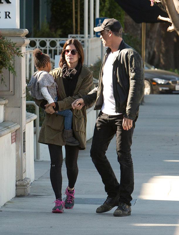 EXCLUSIVE: *** Premium Exclusive Rates Apply*** Sandra Bullock doesn&#8217;t look to impressed with boyfriend Bryan Randall as she holds her daughter Laila while they pick up coffee in Studio City, CA