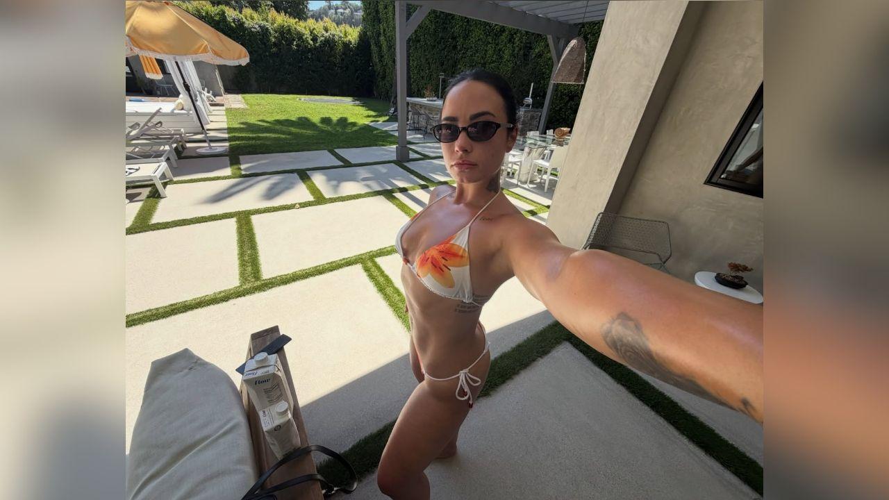 image of Demi Lovato shared vacation photos on Instagram, including a selfie in a white bikini with colorful floral details.